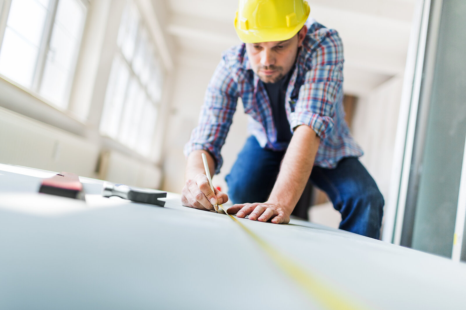 Bauarbeiter mit Schutzhelm auf Baustelle bei der Arbeit.